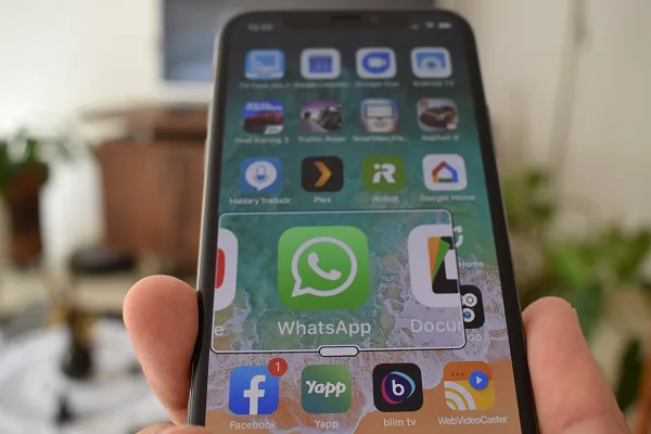 Icône WhatsApp au premier plan sur l'écran d'accueil d'un iPhone
