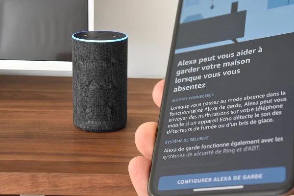 Amazon Echo à côté d'un mobile montrant l'écran de la fonction In Guard of Alexa
