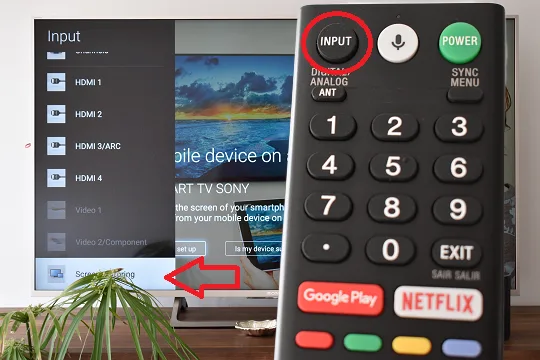 L'image montre la télécommande Sony TV avec le bouton Input en surbrillance et sur l'écran du téléviseur une flèche pointant vers l'option Screen Mirroring.
