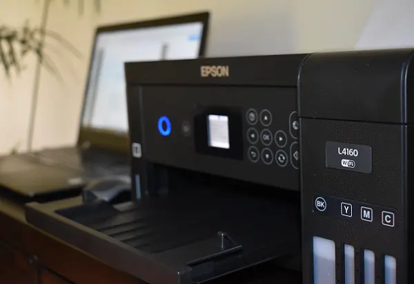 Imprimante EPSON L4160. À côté se trouvent un ordinateur portable et une souris
